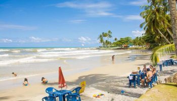Imagem de uma família nas cadeiras do quiosque e crianças na-Praia dos Milionários-Bahia-BA